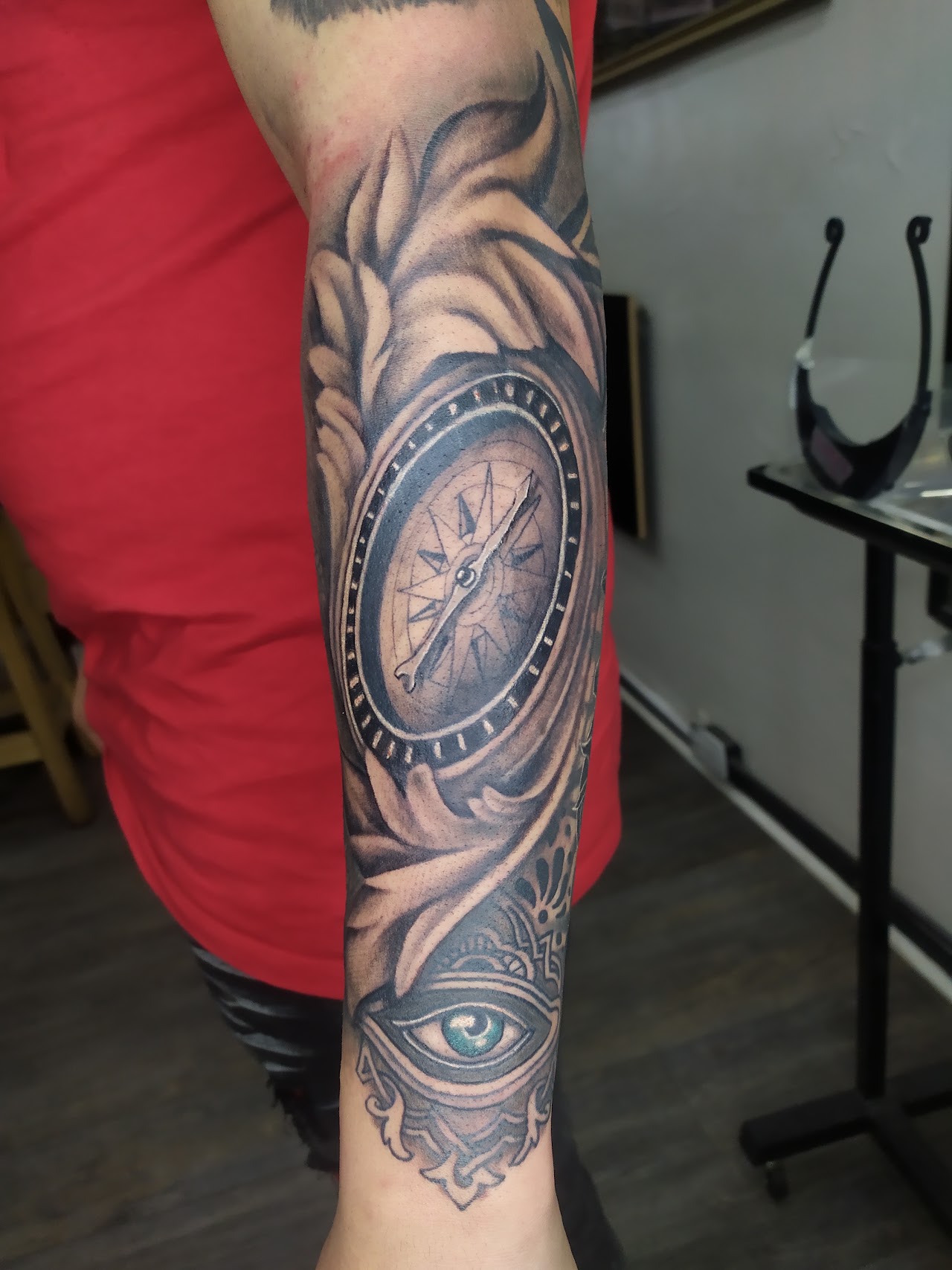 Tatuaje de realismo en blackwork: brújula, manto y ojo, trabajo realizado en Chuma Tattoo studio