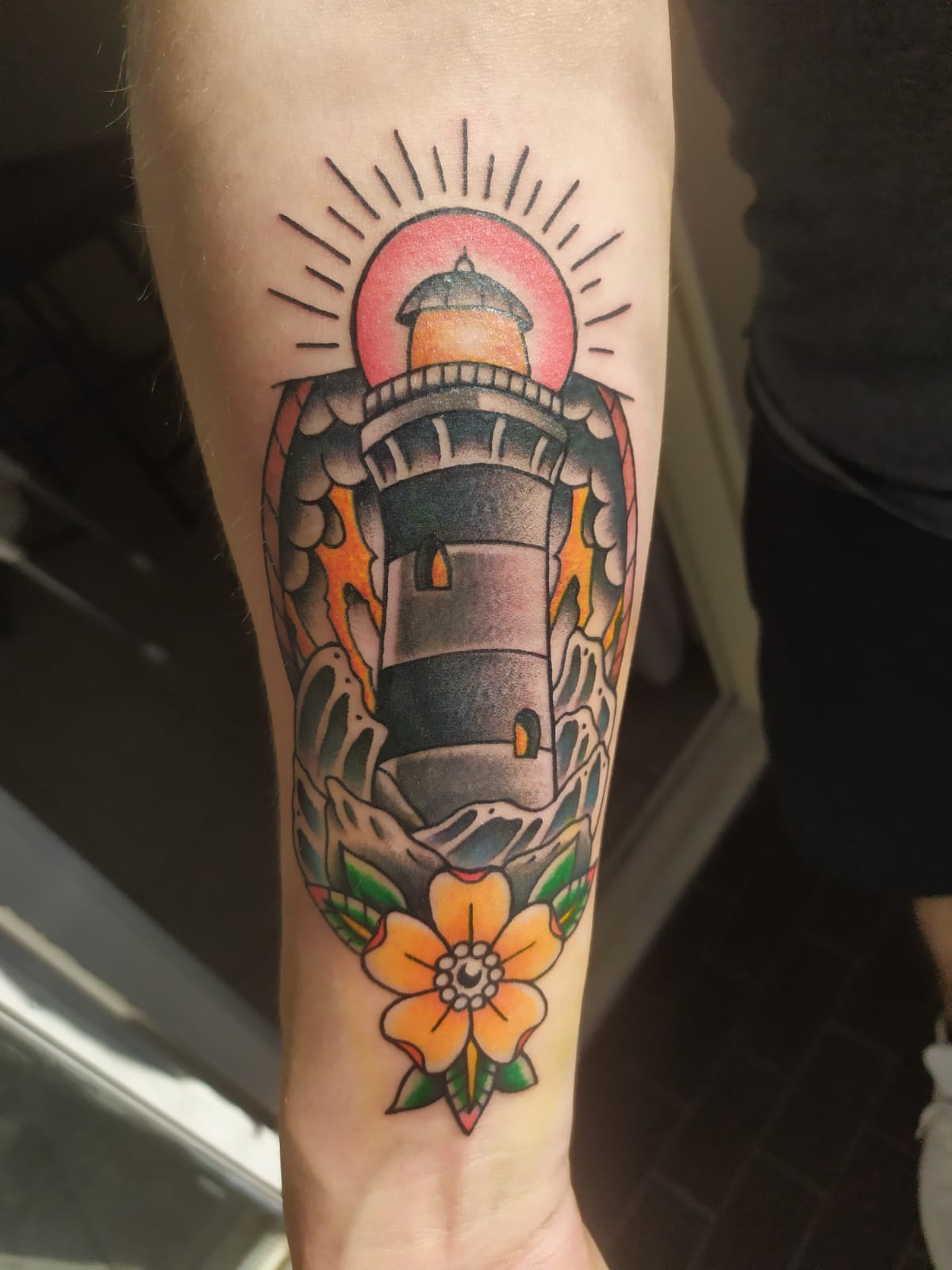 Tatuaje tradicional americano a color de un faro, antebrazo
