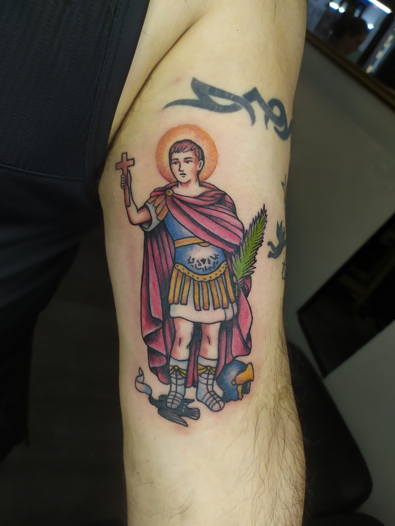Tatuaje tradicional religioso a color de un santo, brazo